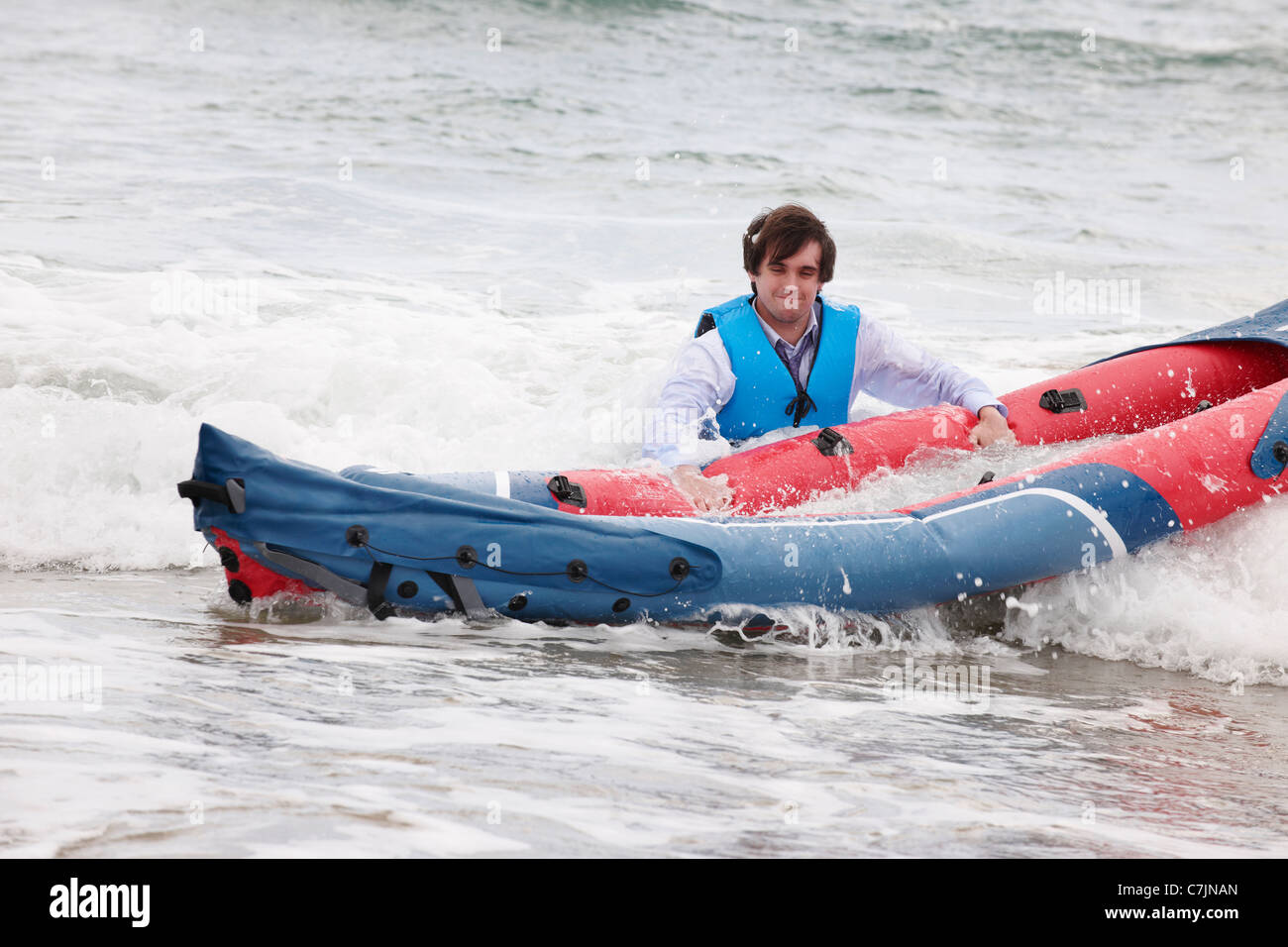 Imprenditore spingendo la canoa in ocean Foto Stock