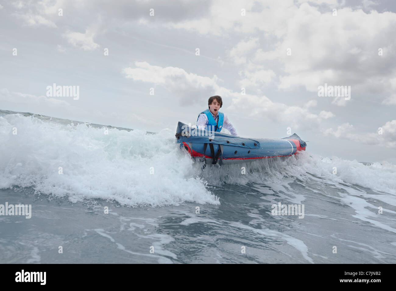 Imprenditore spingendo la canoa in ocean Foto Stock