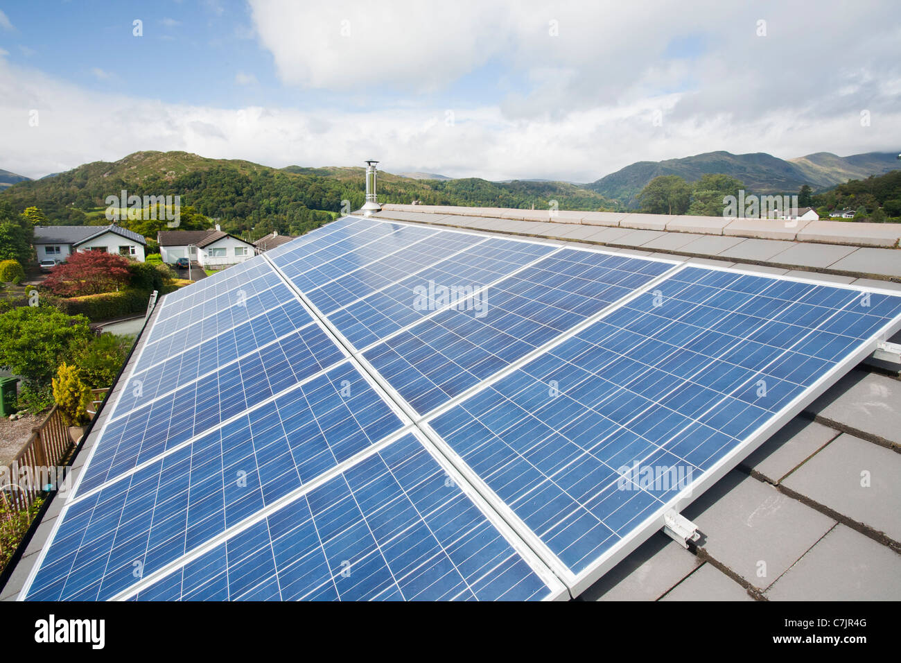 Energia solare fotovoltaica in pannelli su un tetto di casa a Ambleside, Cumbria, Regno Unito. Foto Stock