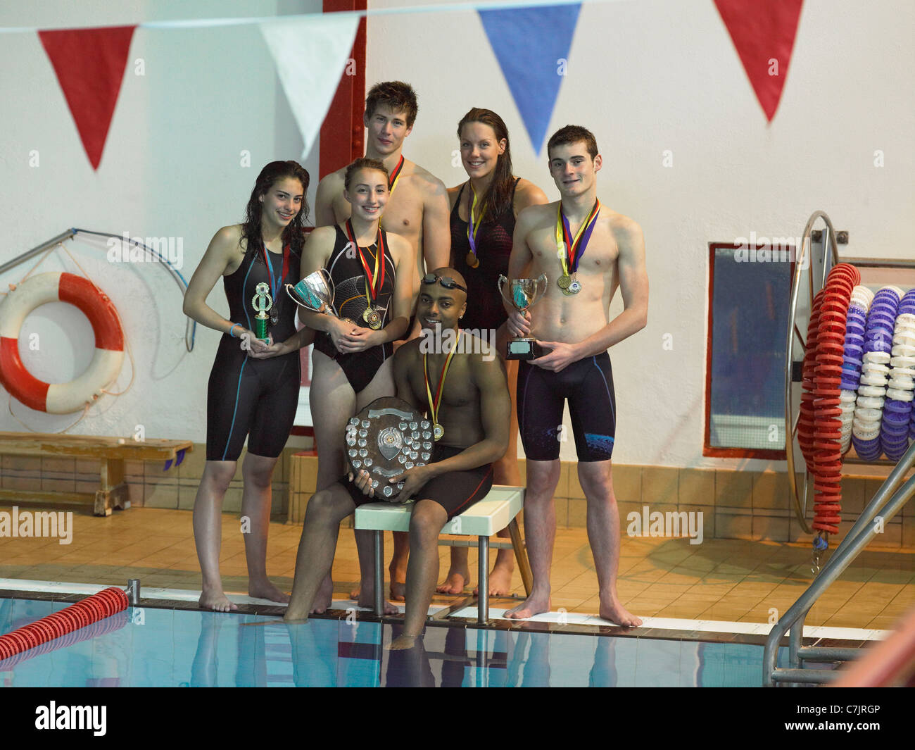Nuotatori tenendo i trofei in piscina Foto Stock