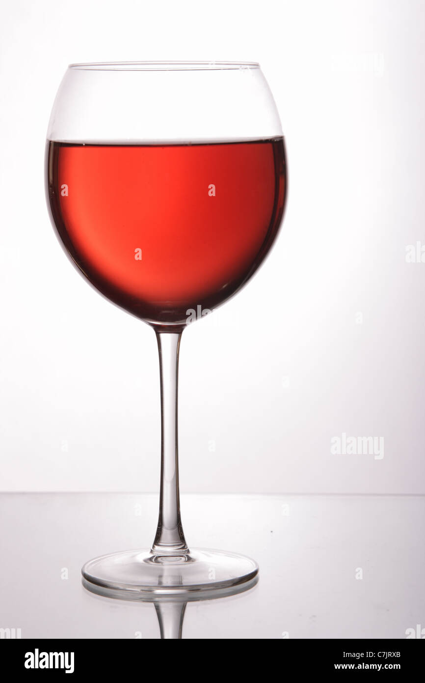 Bicchiere di vino rosso su grigio chiaro sfondo bianco Foto Stock