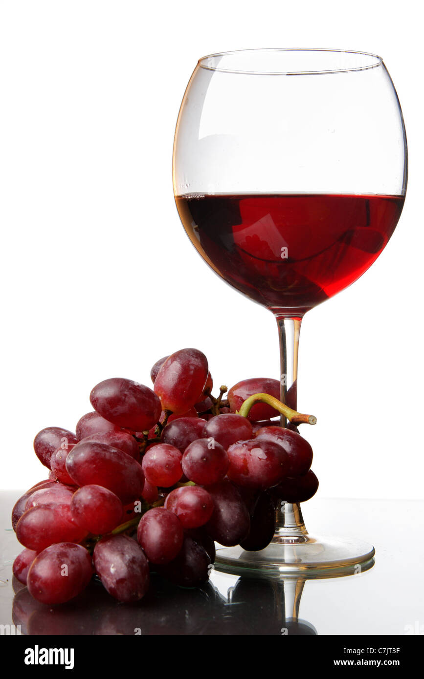 Bicchiere di vino rosso e uva isolate su sfondo bianco Foto Stock