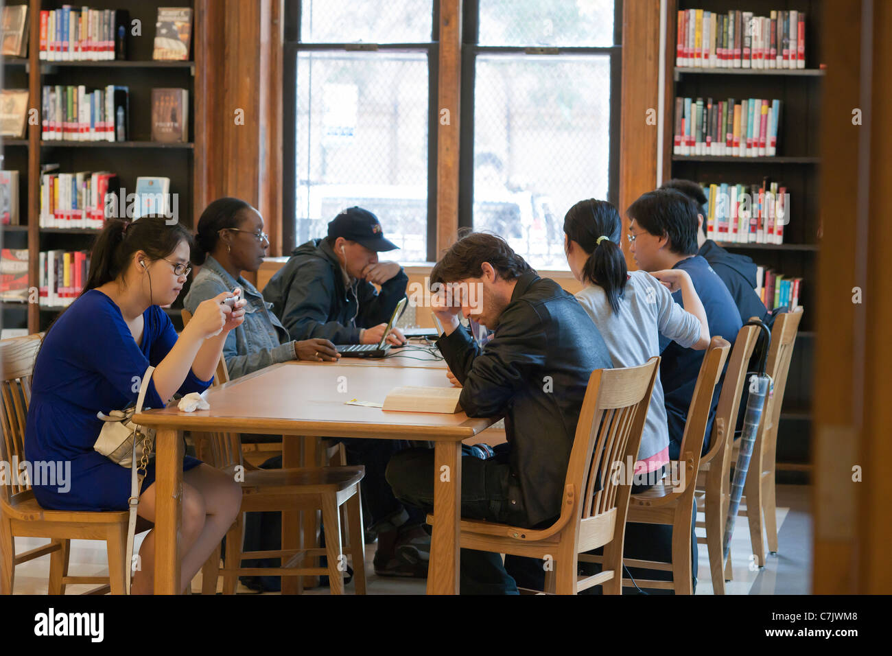 Patroni di leggere, studiare e usare il wi-fi in Seward Park Library in New York Foto Stock