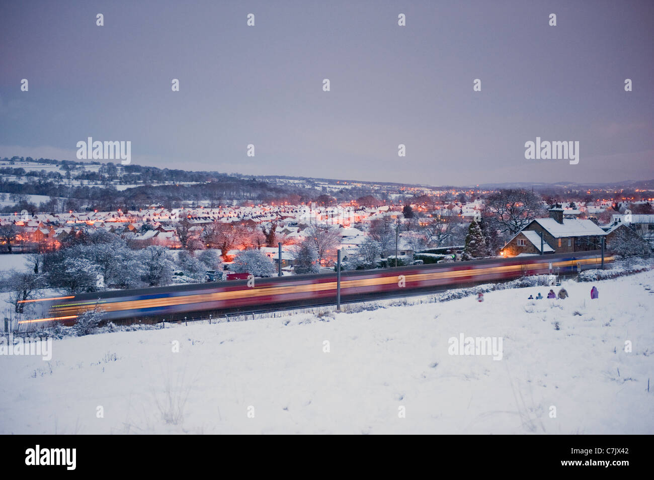 Un treno che corre lungo la linea di Wharfedale in un giorno di neve. Foto Stock