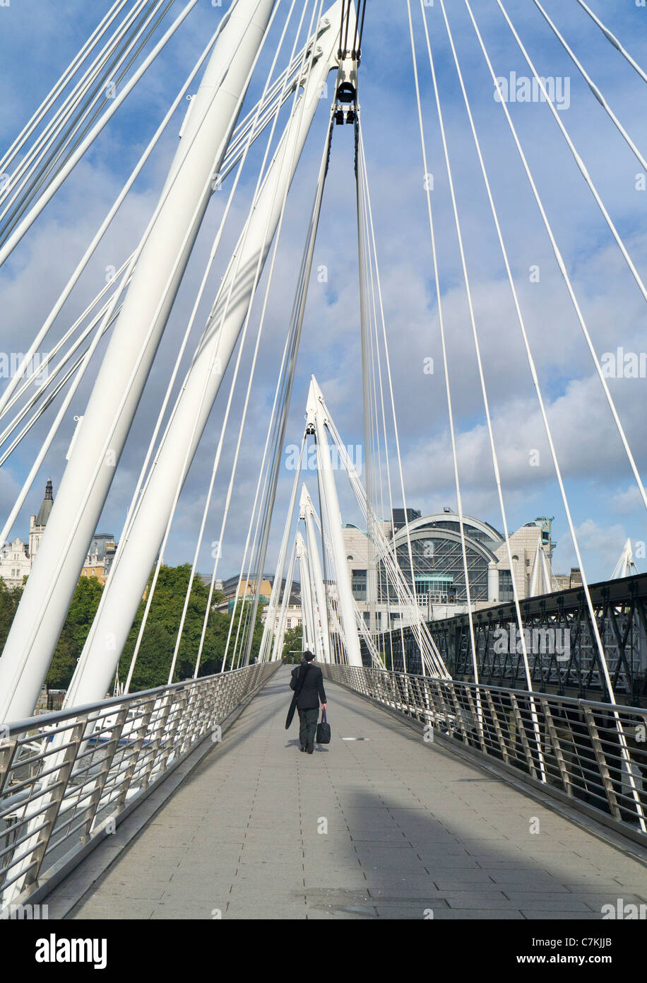 L'uomo attraversando il Millennium Footbridge at Charing Cross, Londra Foto Stock