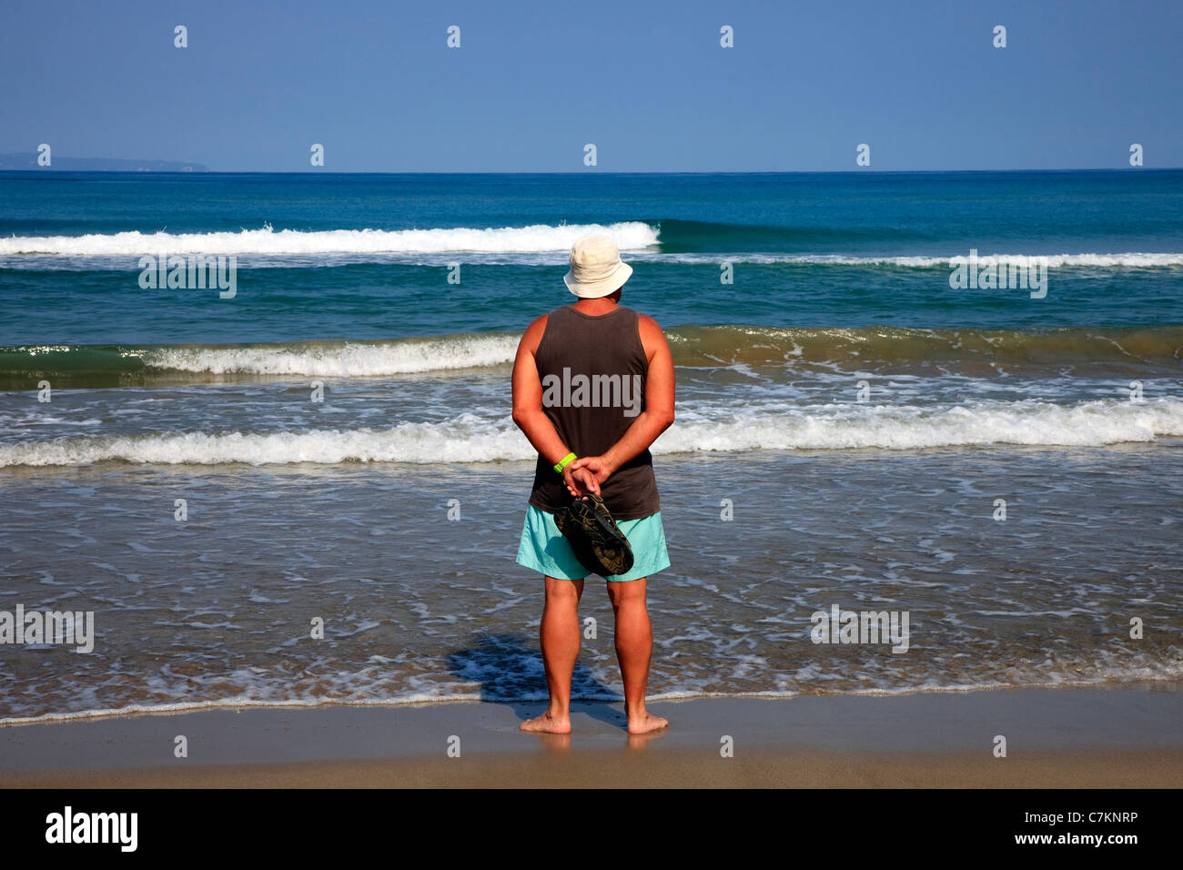Adulto uomo in piedi su una spiaggia affacciata sul mare, Sidari, Corfù, Grecia Foto Stock
