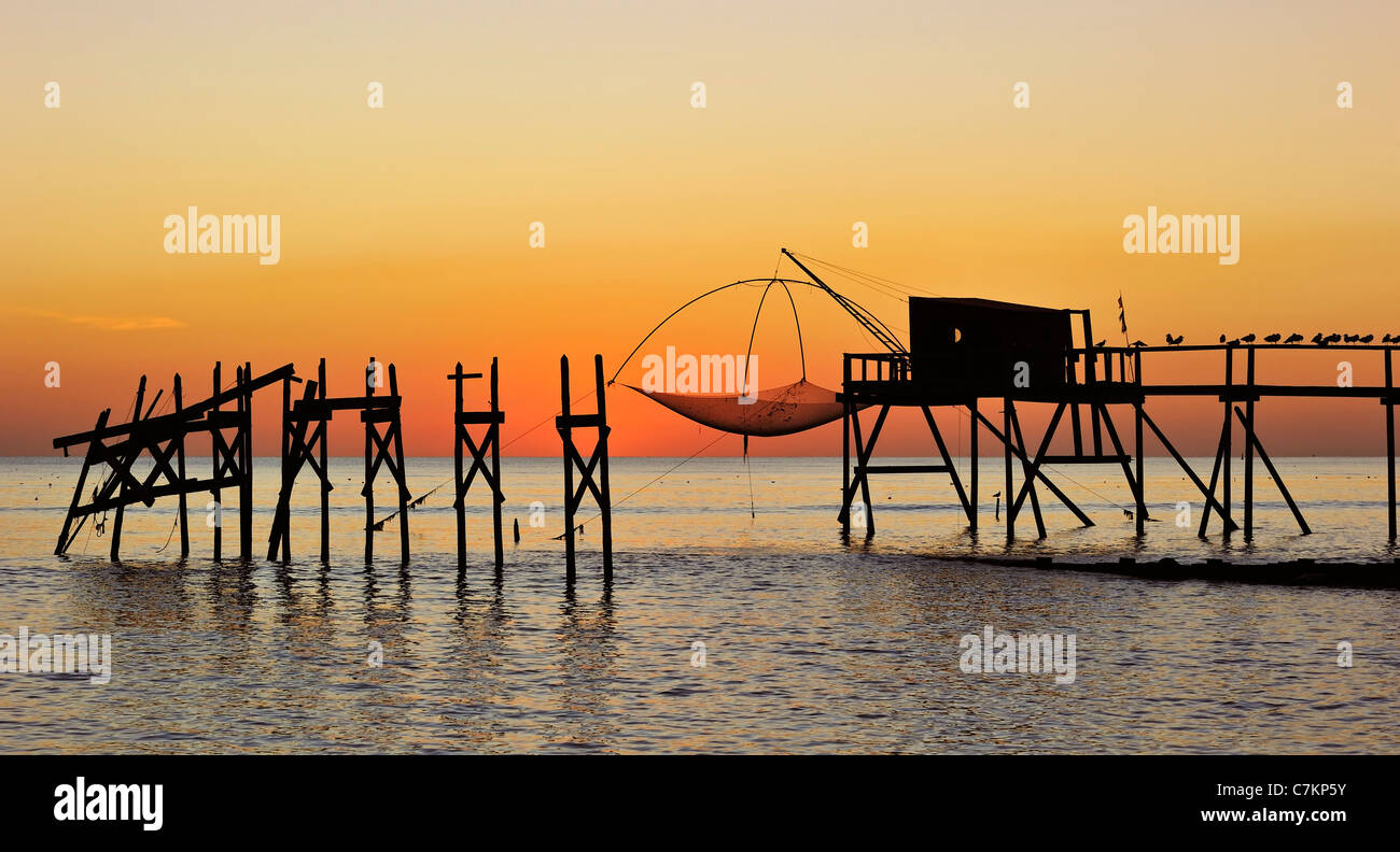 Carrelet tradizionale baita di pesca con rete di sollevamento sulla spiaggia al mare al tramonto, Loire-Atlantique, Pays de la Loire, Francia Foto Stock