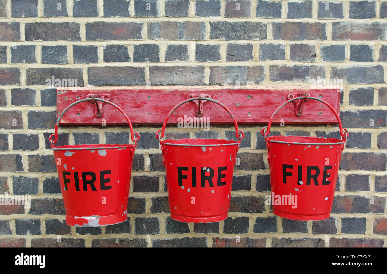 Tre rosso fuoco secchi contro uno scuro muro di mattoni, Quainton Centro ferroviario Foto Stock