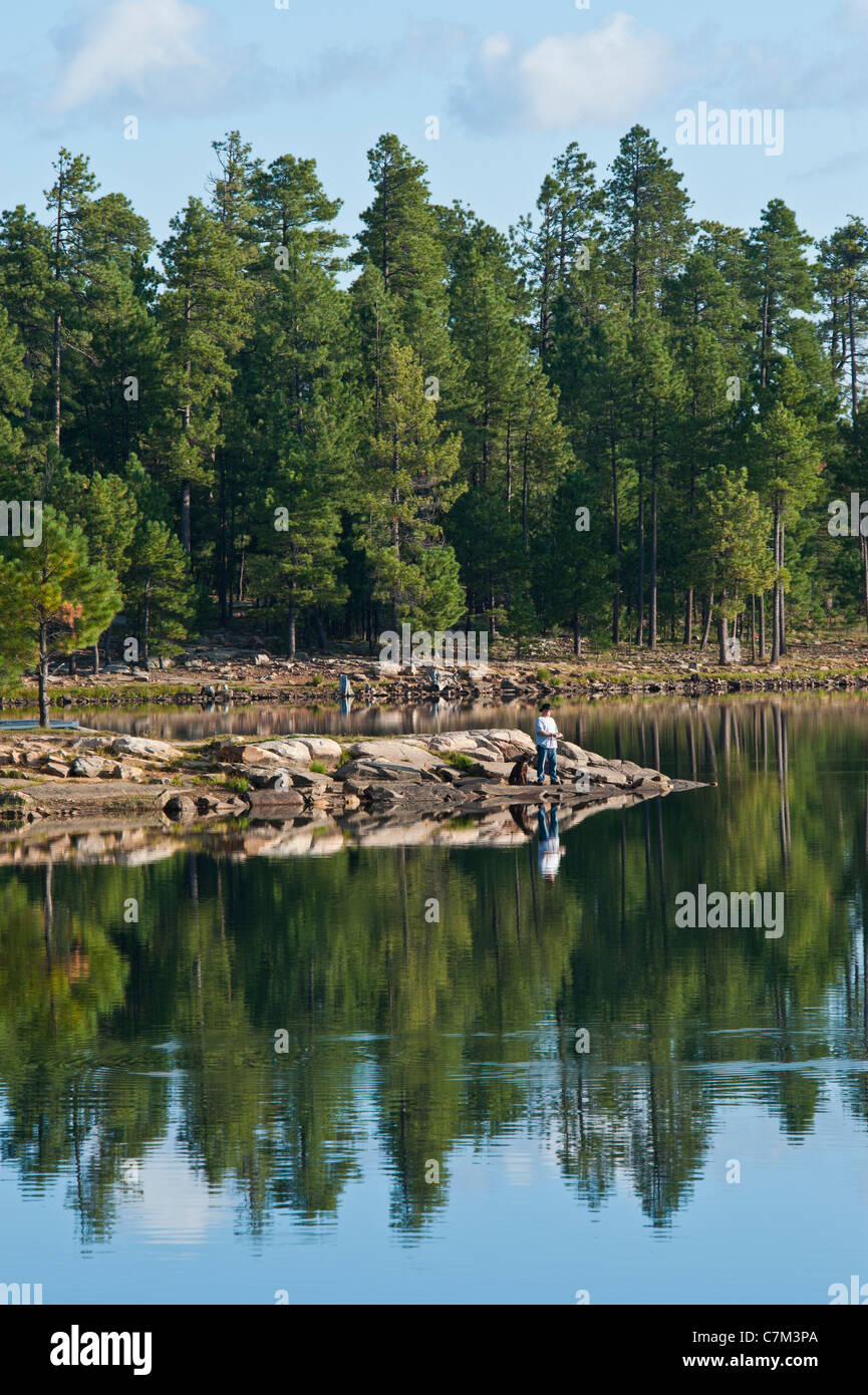 Un uomo e il suo migliore amico facendo qualche pesca prima colazione a Willow Springs Lake, Arizona. Foto Stock