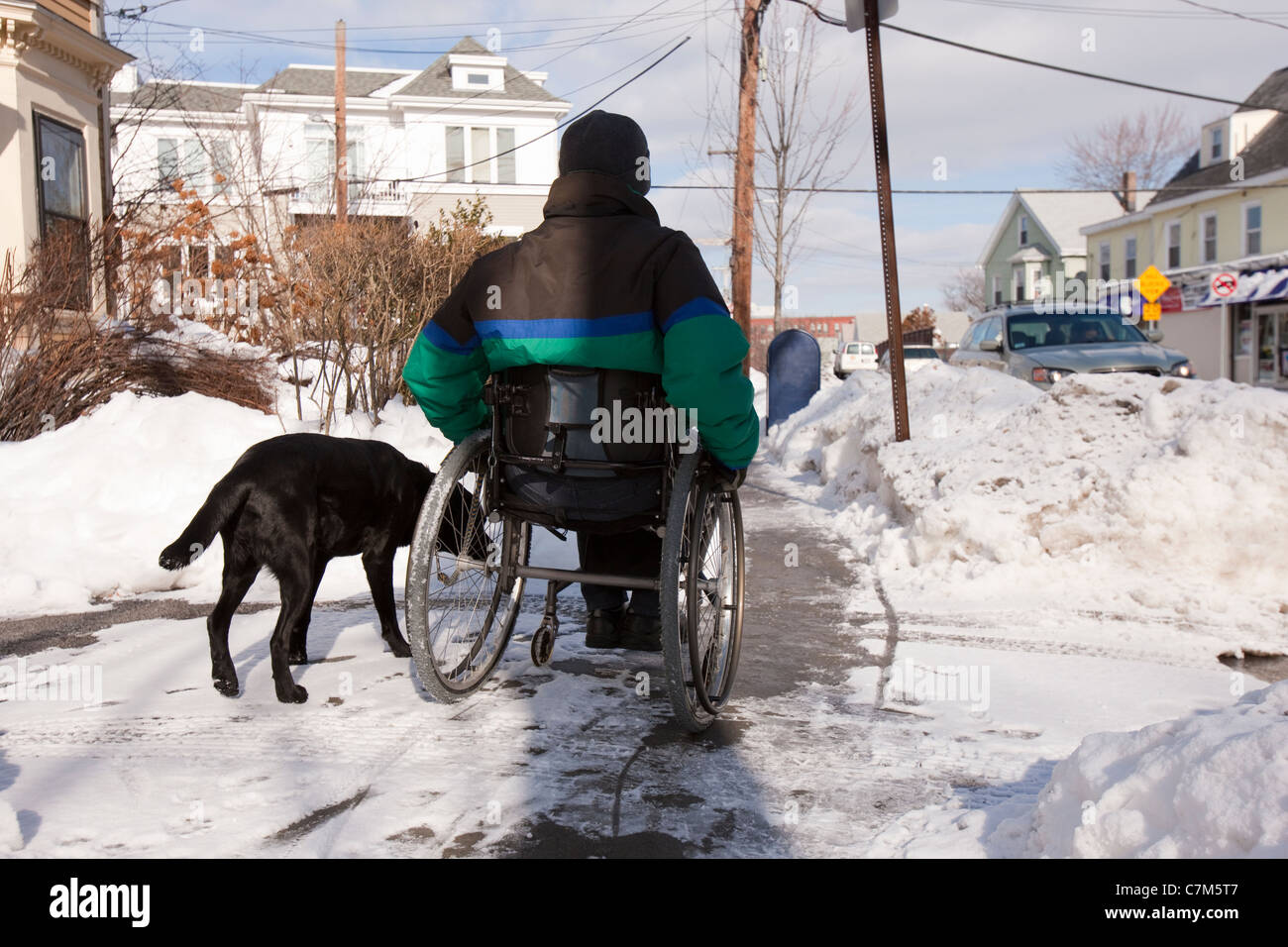 Donna con sclerosi multipla cercando di raggiungere la casella di posta con un cane di servizio Foto Stock