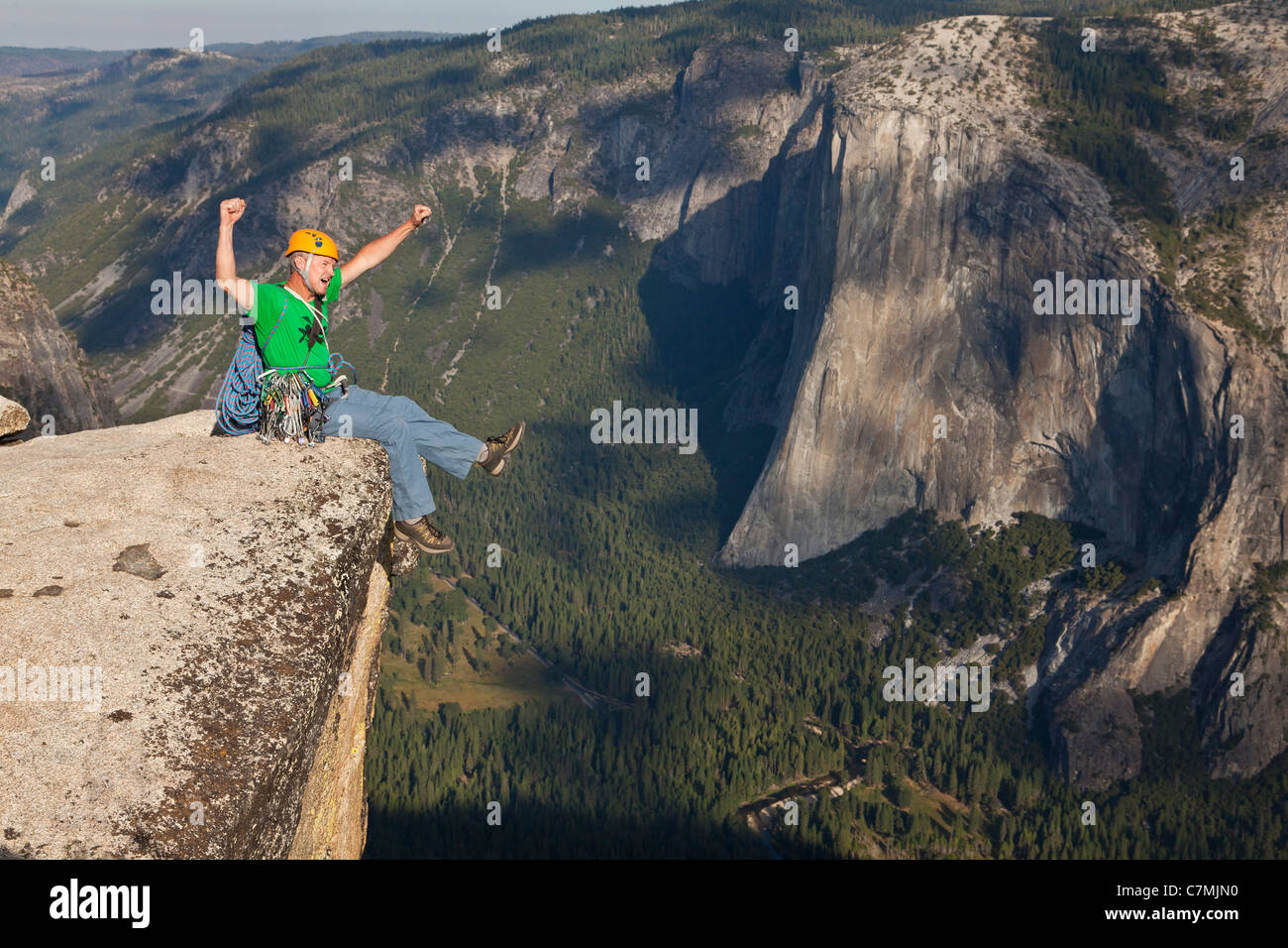 Maschio di rocciatore festeggia sul vertice dopo una salita di successo. Foto Stock