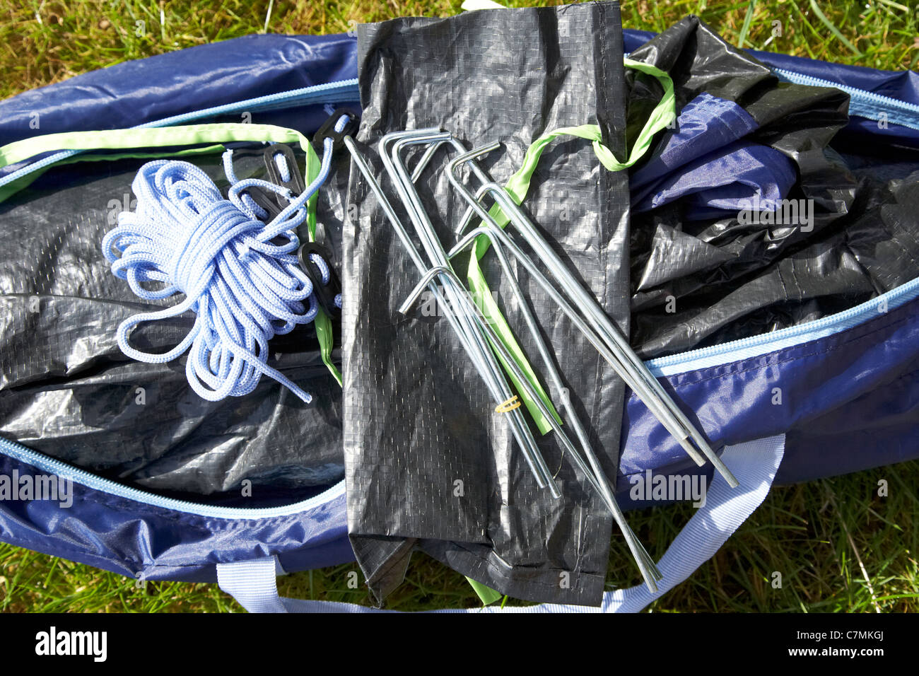 Borsa di picchetti da tenda disimballaggio di una piccola tenda in un  sacchetto che giace sull'erba Foto stock - Alamy
