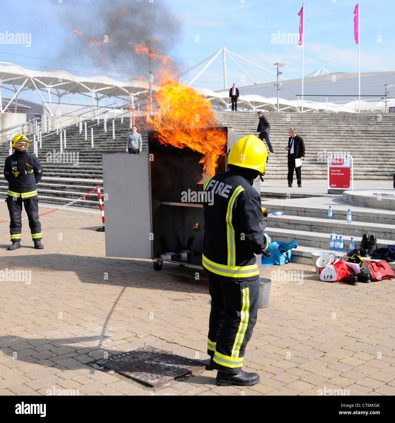 Le fiamme da hot chip pan fire tipo di pericolo se utilizzando acqua da Londra Vigili del Fuoco vigili del fuoco in uniforme di salvataggio sfida evento a Londra England Regno Unito Foto Stock