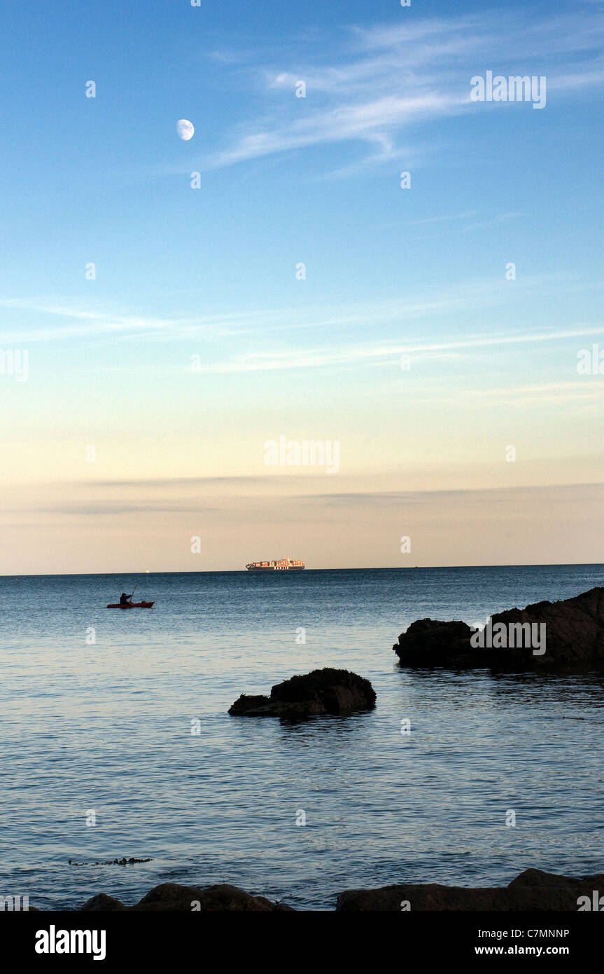 Canoa un'attività all'aperto, da Meadfoot beach in Torquay.Hanjin nave sulla skyline e la luna, attività, avventura, barca, Foto Stock