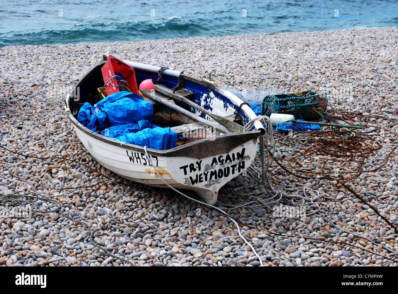 Piccola barca sulla spiaggia a Chiswell Portland Dorset Inghilterra con [Riprova Weymouth] dipinto sul suo stern Foto Stock