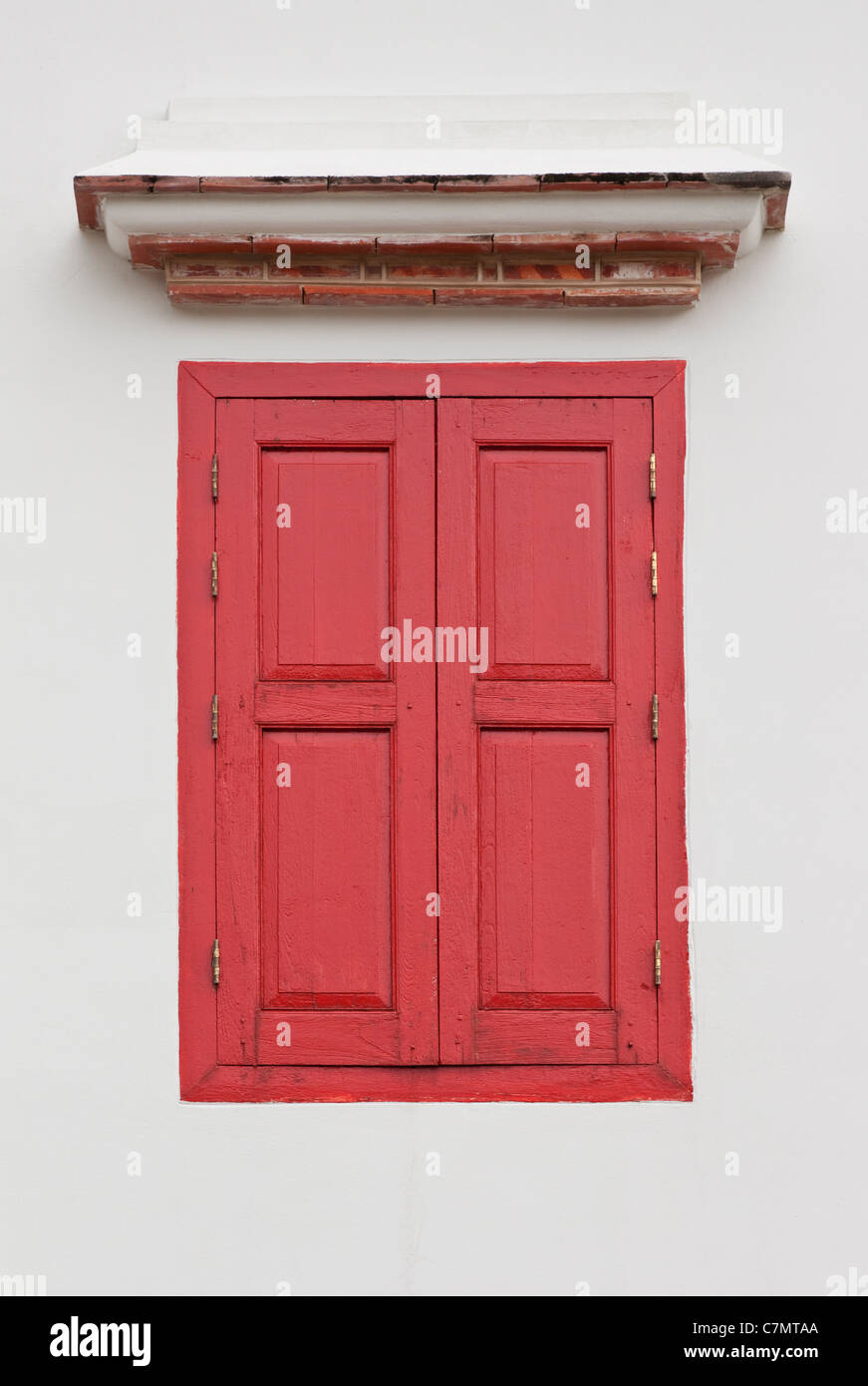 Una finestra con persiane rosse. Foto Stock