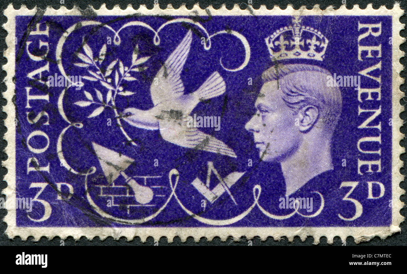 Regno Unito - 1946: un francobollo dedicato alla fine della II Guerra Mondiale, raffigura il re George VI e simboli di pace e industria Foto Stock