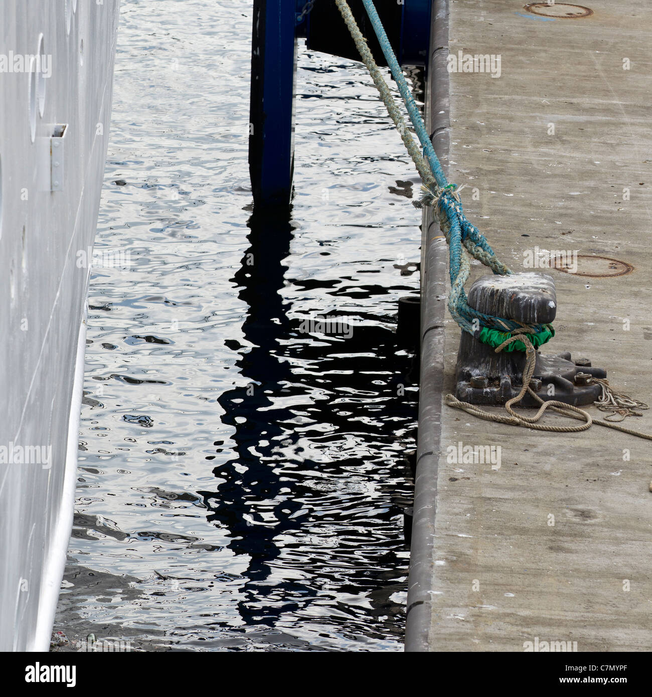 Abstract riflessioni in acqua dove una nave passeggeri è collegato a un bollard Foto Stock