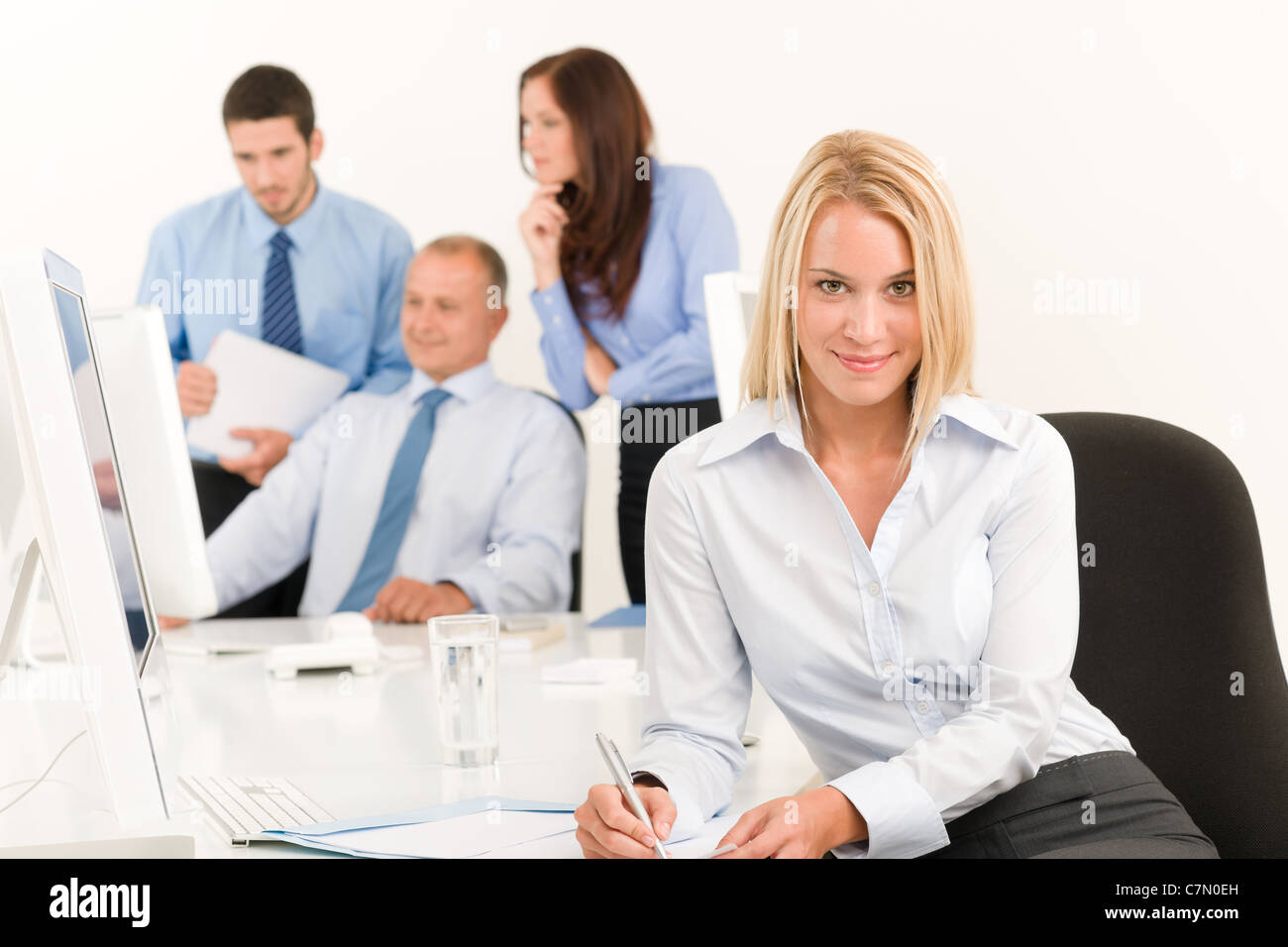 Il team di Business piuttosto giovane imprenditrice ritratto con i colleghi intorno al tavolo Foto Stock