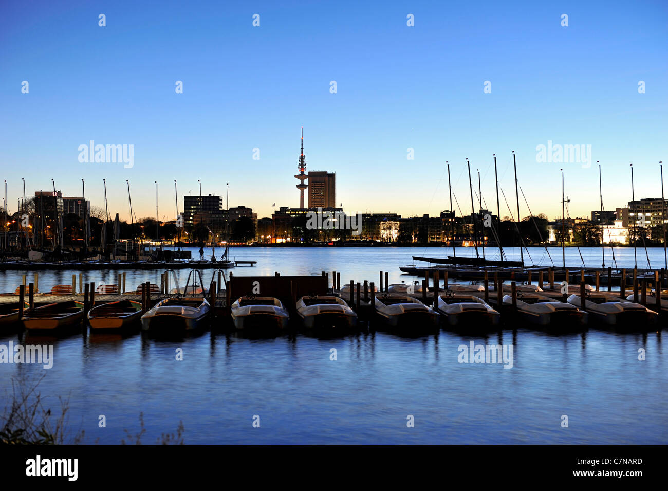 Barche a vela, i montanti con illuminazione posteriore al tramonto sull'esterno lago Alster, città anseatica di Amburgo, Germania, Europa Foto Stock