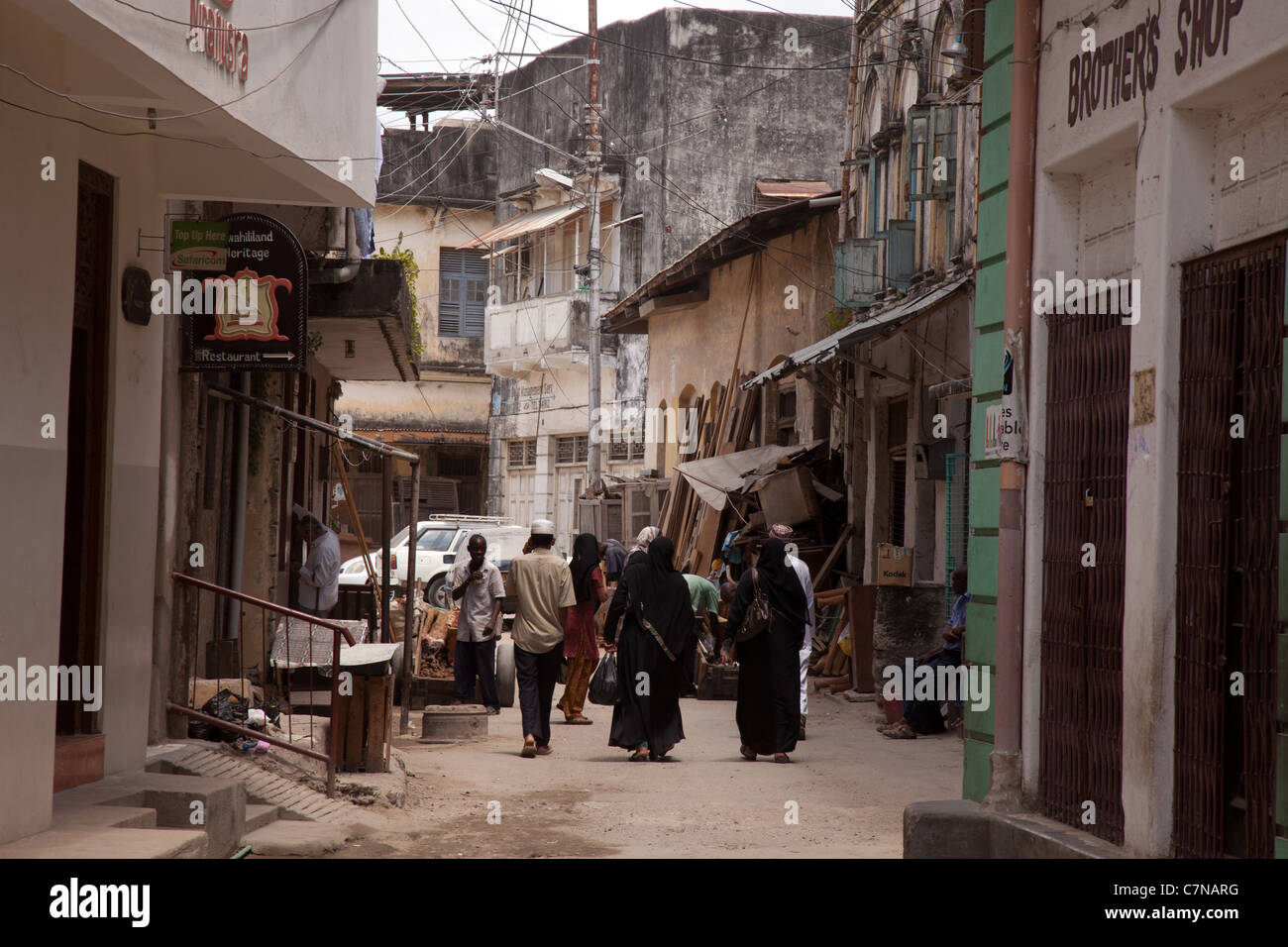 Donna musulmana in Burkas camminando attraverso il vicolo, la città vecchia di Mombasa, sito patrimonio mondiale dell'UNESCO, Kenya, Africa Foto Stock