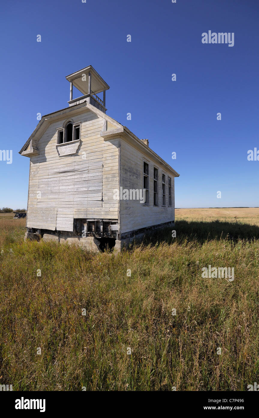 Vecchio schoolhouse abbandonati nel mezzo di un campo in Saskatchewan in Canada. Foto Stock