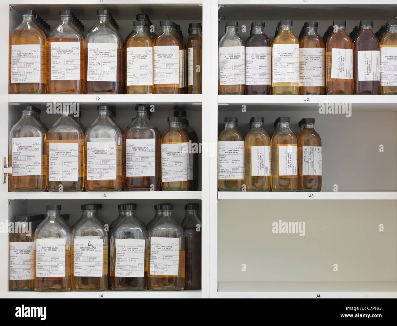 Bottiglie per campione sui ripiani Foto Stock