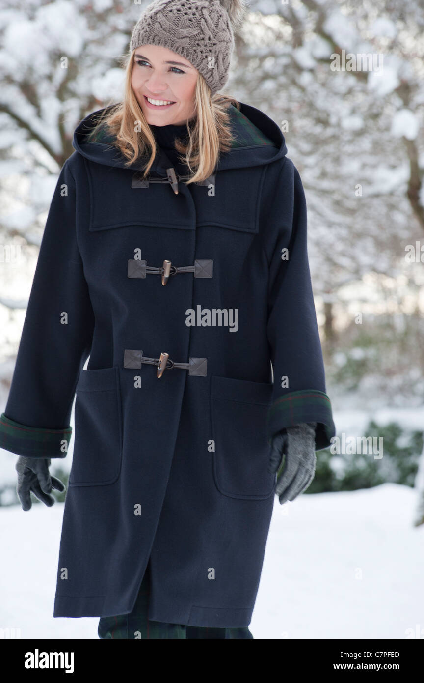 Donna in cappotto pesante a piedi nella neve Foto stock - Alamy