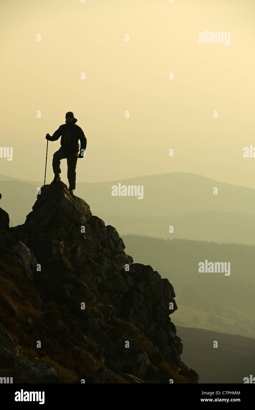 Uomo che passeggia sulla collina rocciosa Foto Stock