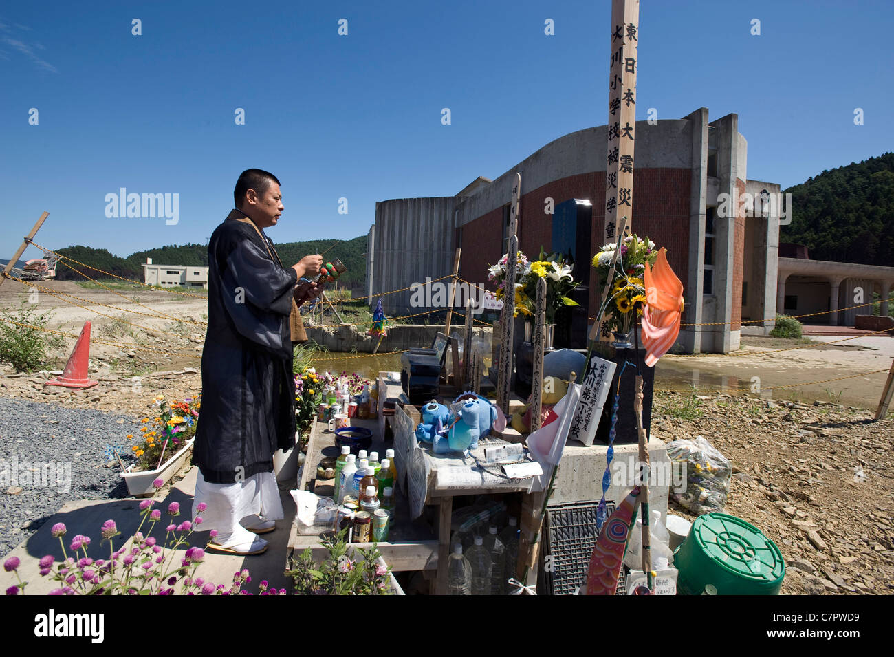 Un prete buddista offre la preghiera per i 74 gli studenti della scuola elementare e gli insegnanti che sono stati spazzati via nel marzo catastrofi Foto Stock