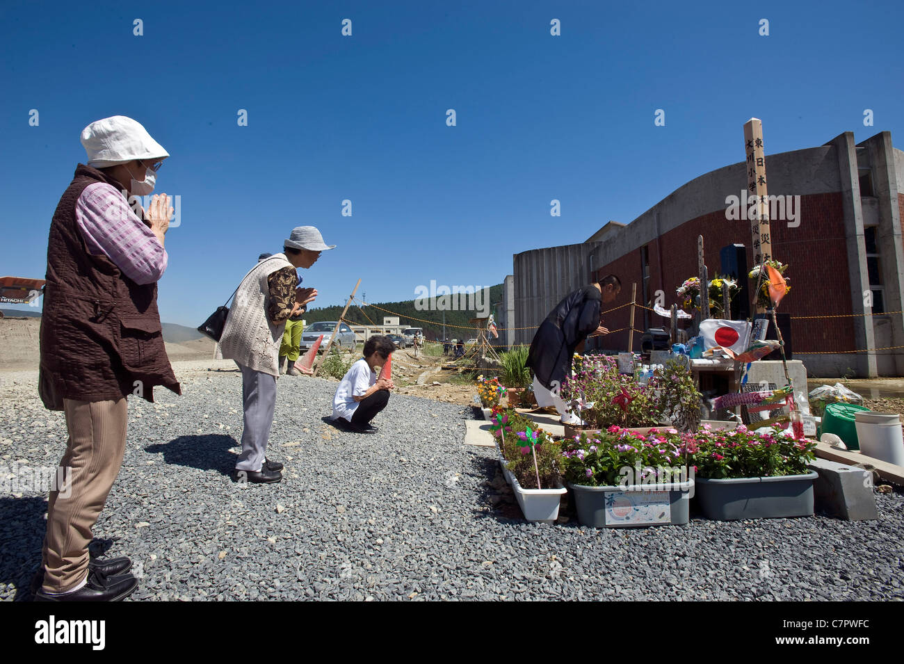 Il sacerdote e i residenti di pregare per i bambini uccisi in marzo al di fuori dello tsunami Okawa scuola elementare a 6 mese anniversario Foto Stock