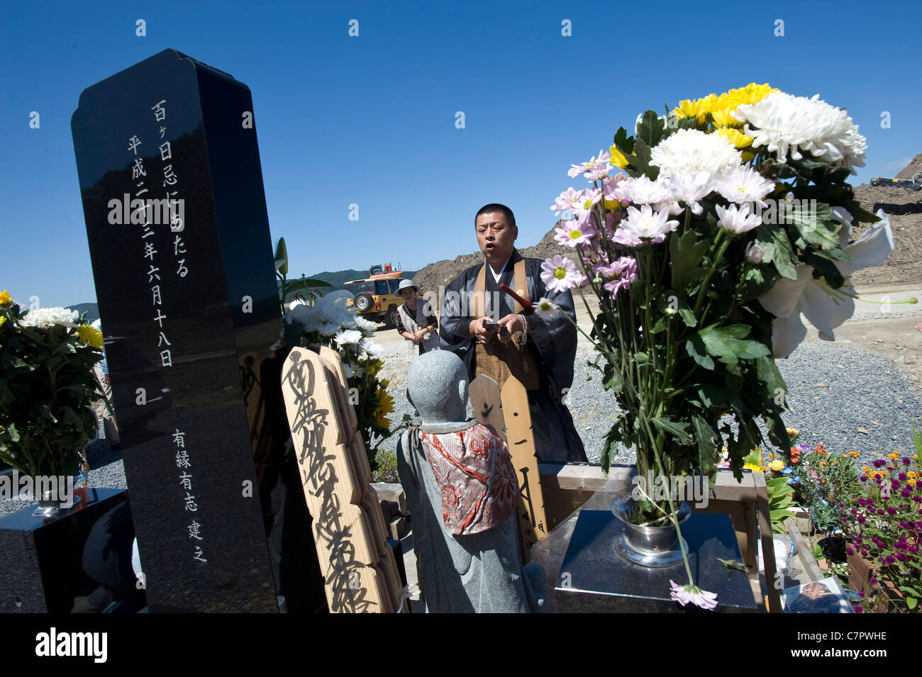 Un prete buddista prega per i 74 bambini e insegnanti di Okawa scuola elementare che erano stati spazzati via durante il mese di marzo tsunami Foto Stock