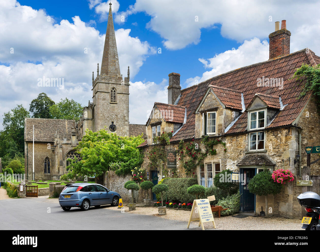 Sala da tè e negozi di artigianato di fronte alla chiesa di San Ciriaco nel pittoresco villaggio di Lacock, vicino a Chippenham, Wiltshire, Regno Unito Foto Stock