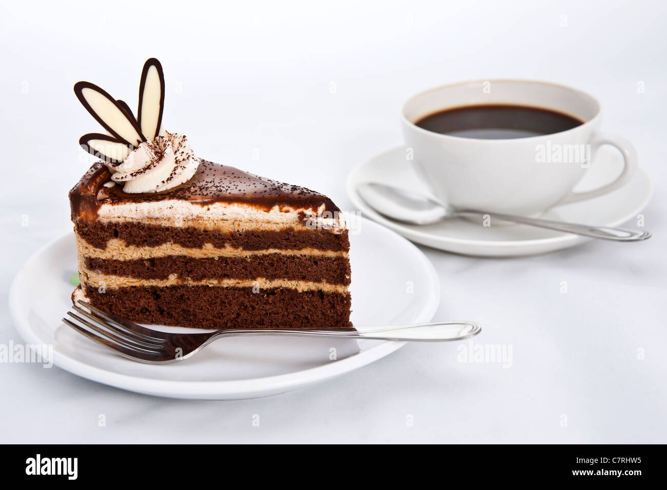 Tre strati di torta al cioccolato con caffè caldo Foto Stock