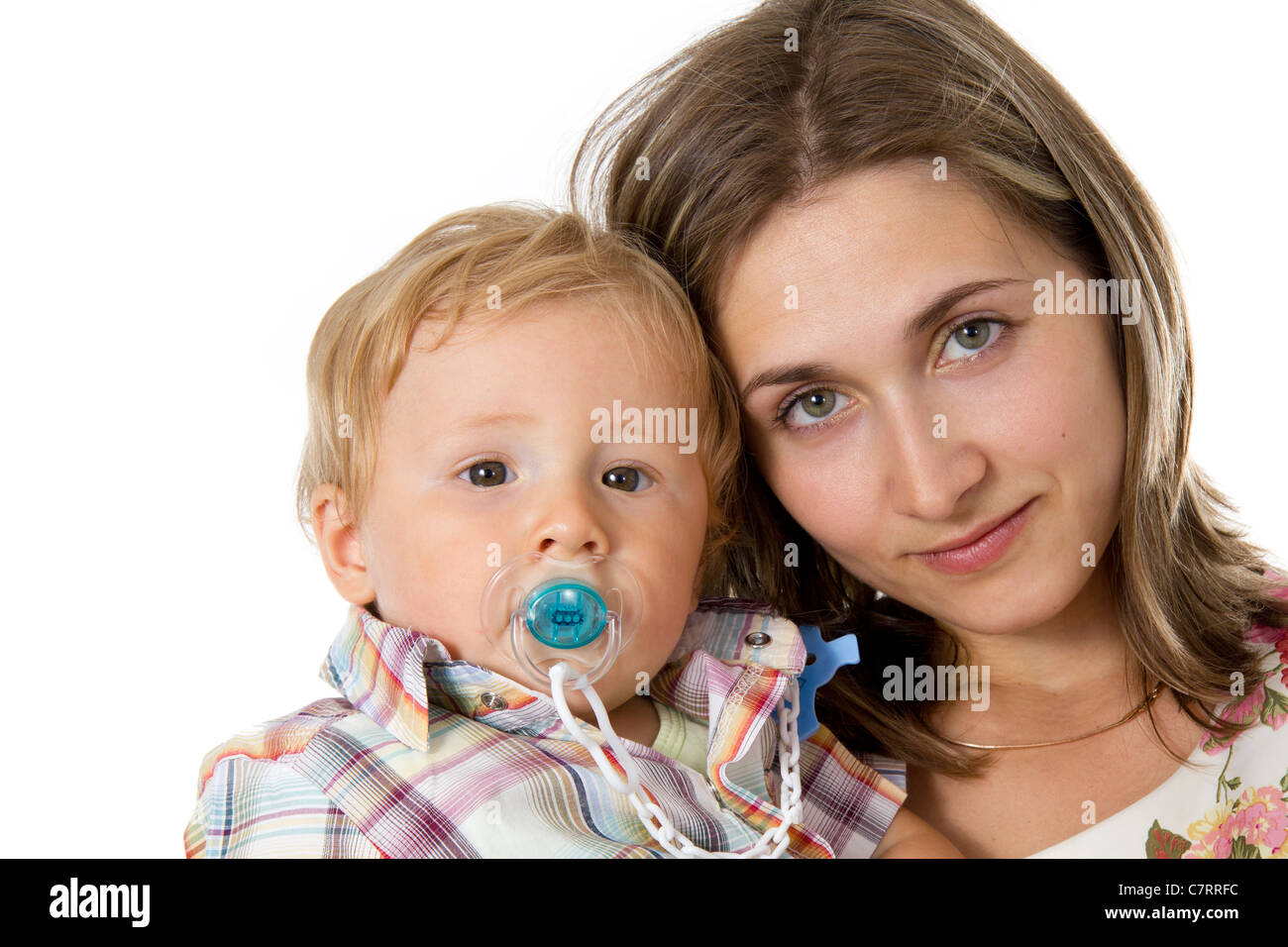 Bambino con un manichino nella sua bocca su mani alla madre Foto Stock