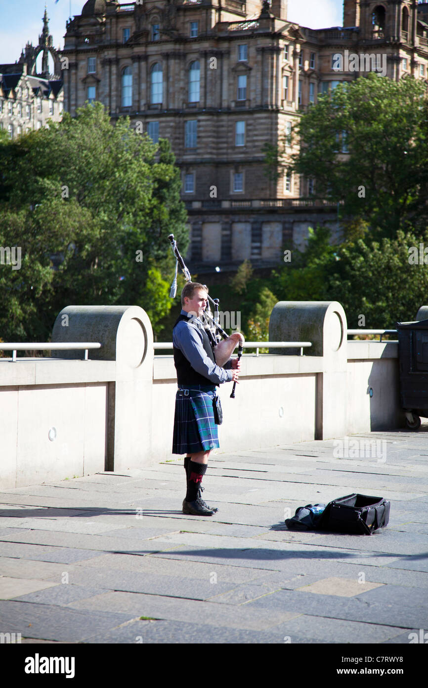 L'uomo bagpiper giocando bagpipes su Street di Edimburgo, Scozia iconico vista suonatore di cornamusa scozzese in kilt musicista di strada Foto Stock