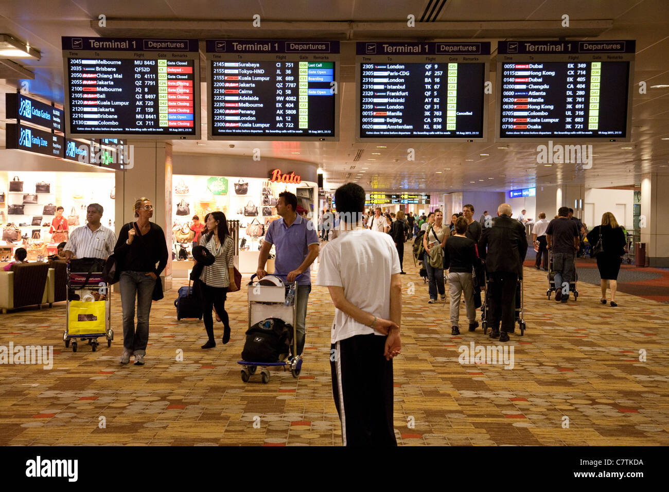 Passeggeri guardando le partenze di amministrazione, l'Aeroporto Changi di Singapore asia Foto Stock