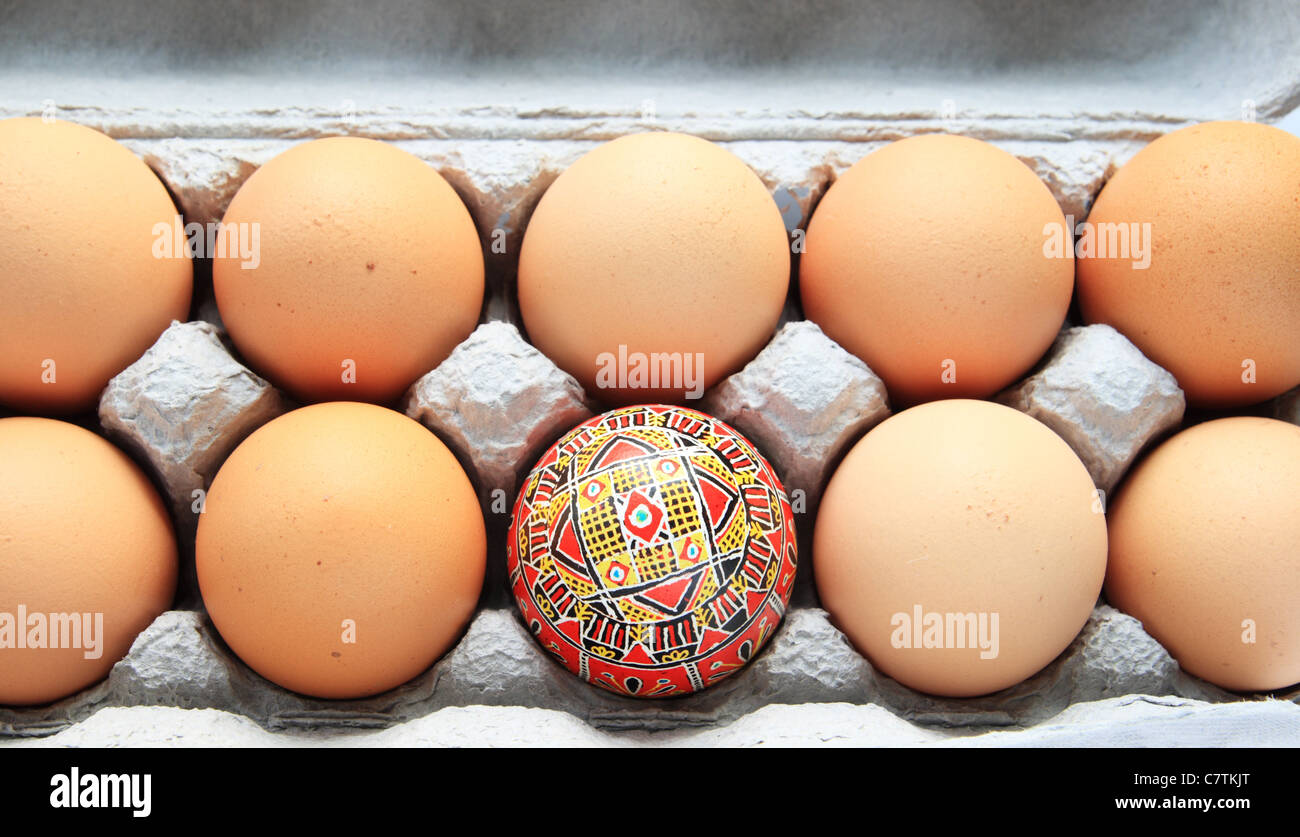Giallo e rosso pysanka uovo di pasqua in una scatola di cartone di uova di colore marrone Foto Stock