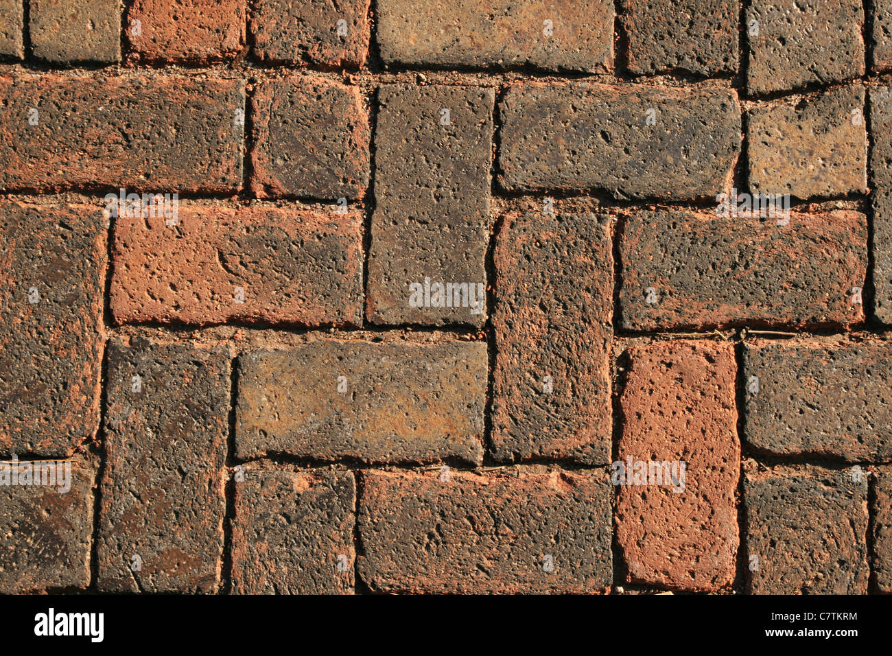 Sfondo di mattoni rossi in una struttura a lisca di pesce da un passaggio pedonale Foto Stock