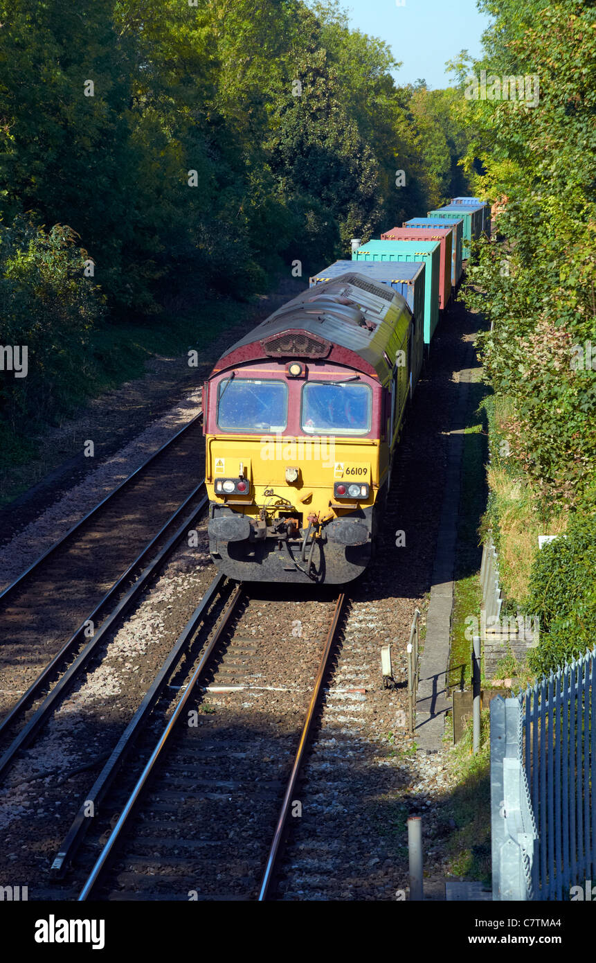 Contenitore EWS treno su South Western mainline (London-Bournemouth) appena a sud di Winchester, Hampshire, Inghilterra. Classe 66 loco. Foto Stock