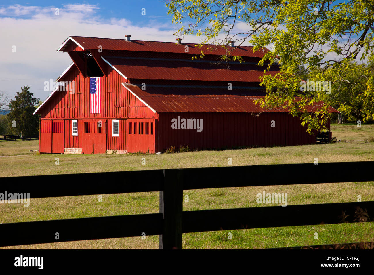 Granaio rosso con bandiera americana vicino a Franklin nel Tennessee USA Foto Stock