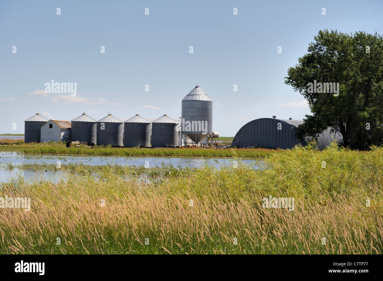 Un paesaggio della prateria shot che mostra grano deposito bidoni e recenti inondazioni di terreni agricoli in Saskatchewan, Canada. Foto Stock