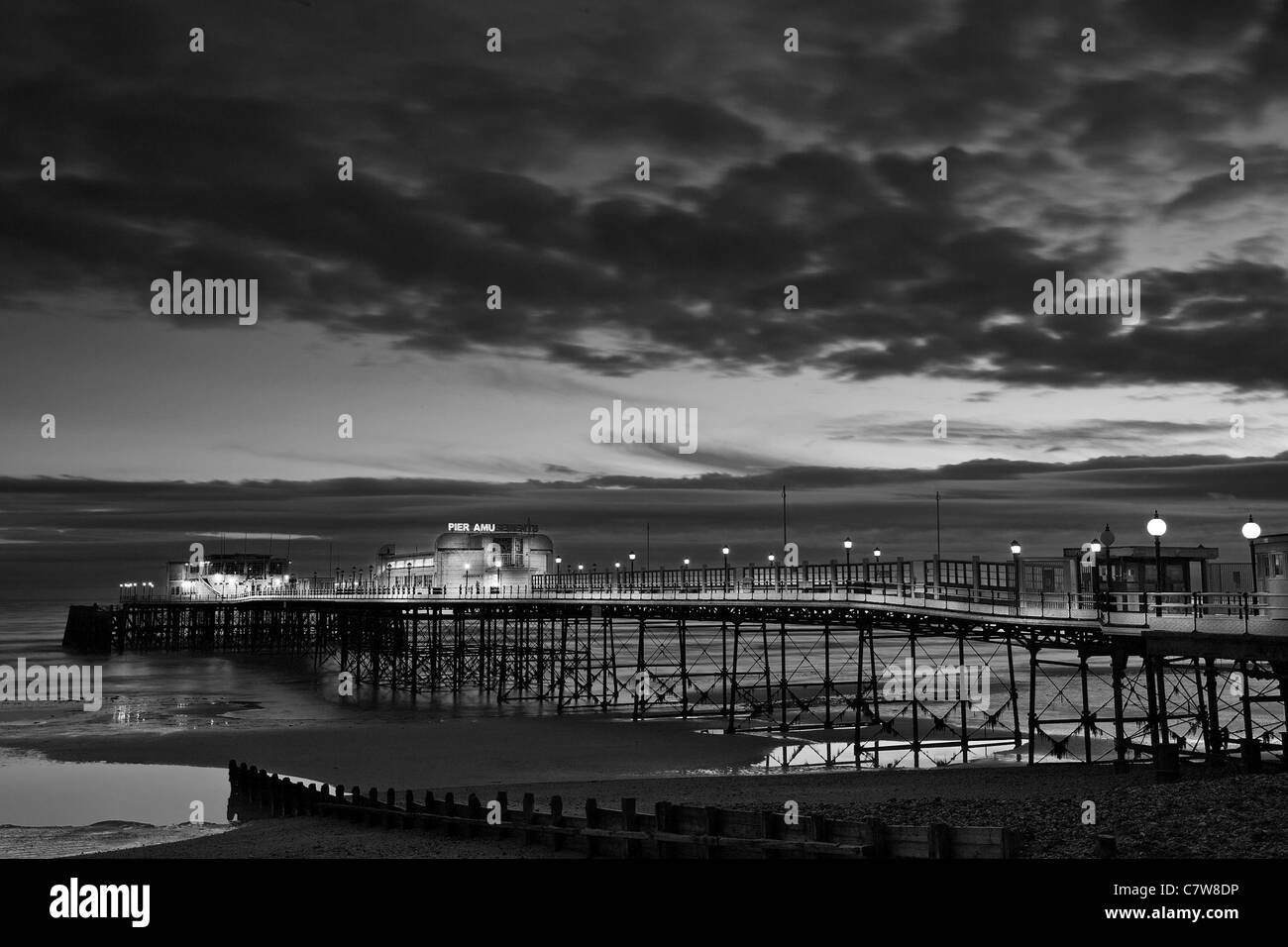 Worthing Pier, West Sussex, cielo nuvoloso,in bianco e nero di notte Foto Stock