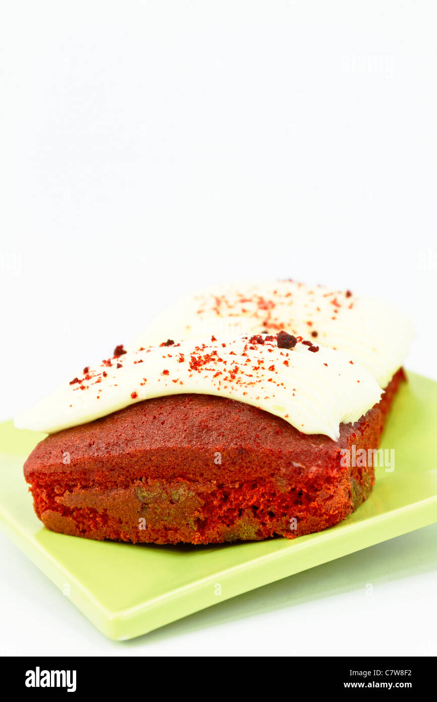 Iced, torta rossa del velluto, 2 mini-focacce su un quadrato, verde piastra; copia sopra lo spazio in verticale immagine ripresa. Foto Stock