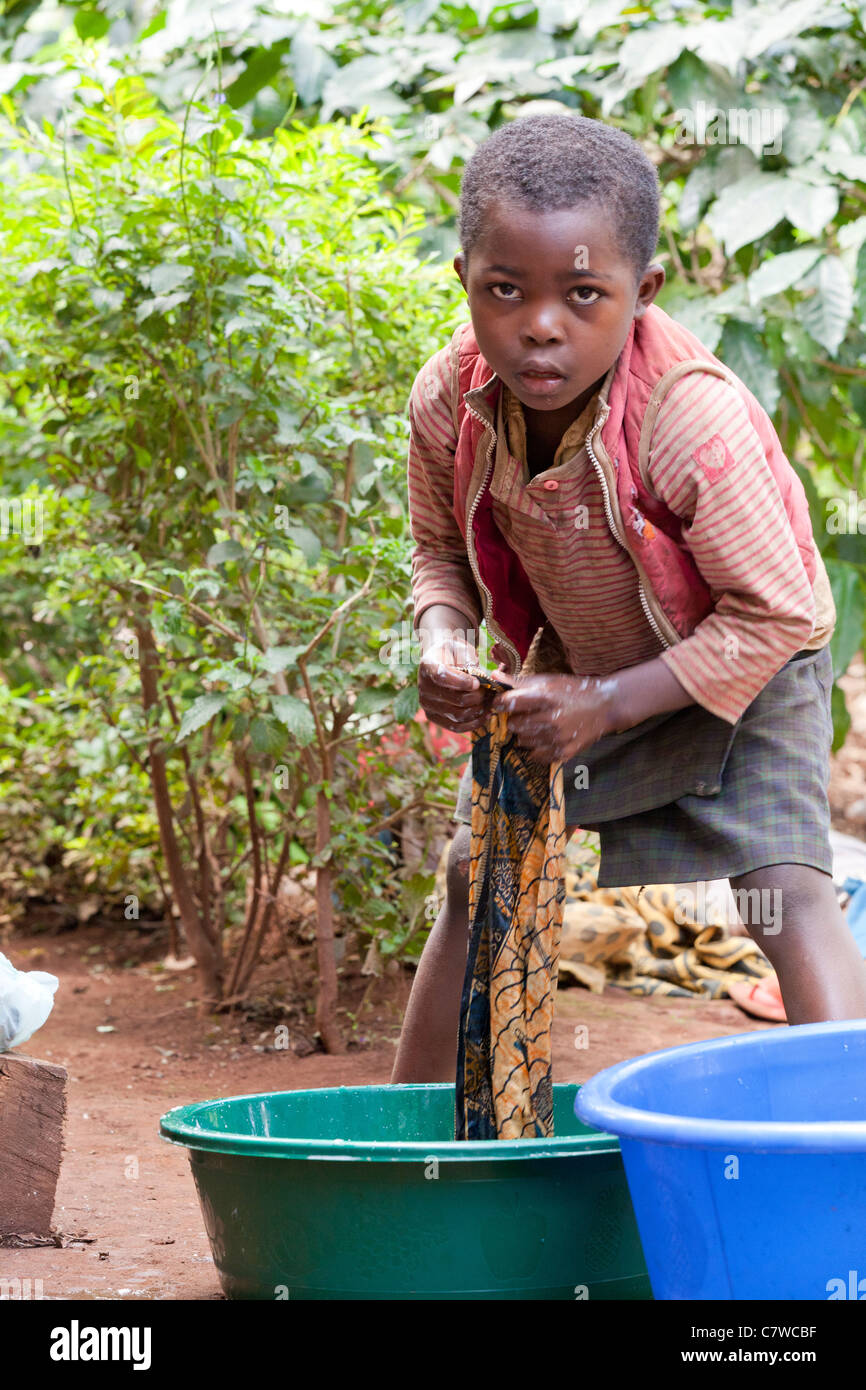 Giovane ragazzo tanzaniano Servizio lavanderia Lavaggio a mano in secchielli in plastica, Mrimbo Uuwo, Moshi, Tanzania, Foto Stock