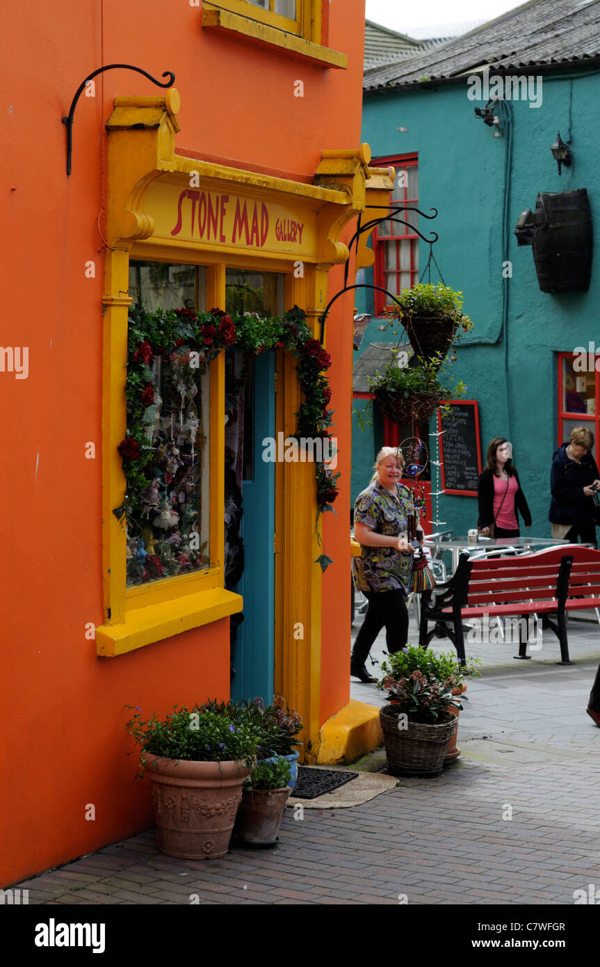 La gente che camminava shop shopping street scene kinsale Cork in Irlanda vivacemente colorati edifici colorati negozi Foto Stock