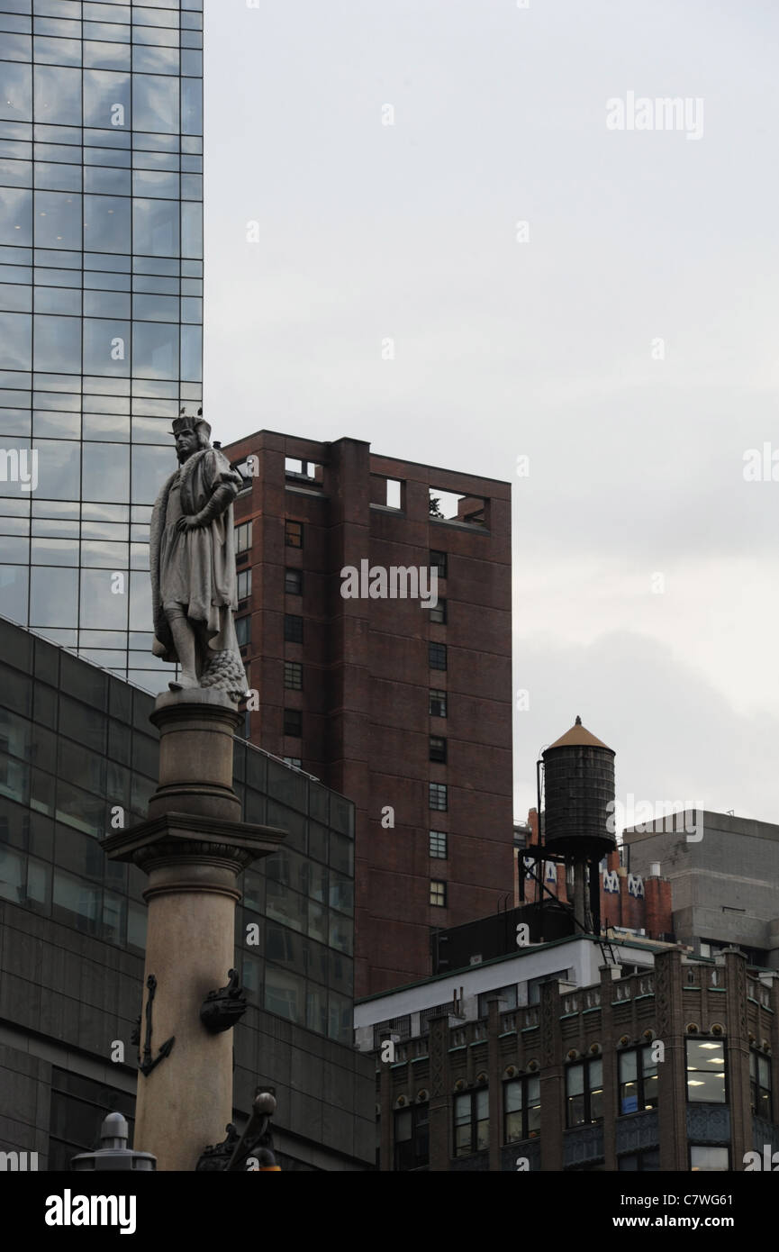 Statua in marmo Christopher Columbus alto zoccolo di granito nella parte anteriore del mattone di vetro serbatoio acqua grattacieli, Columbus Circle, New York Foto Stock