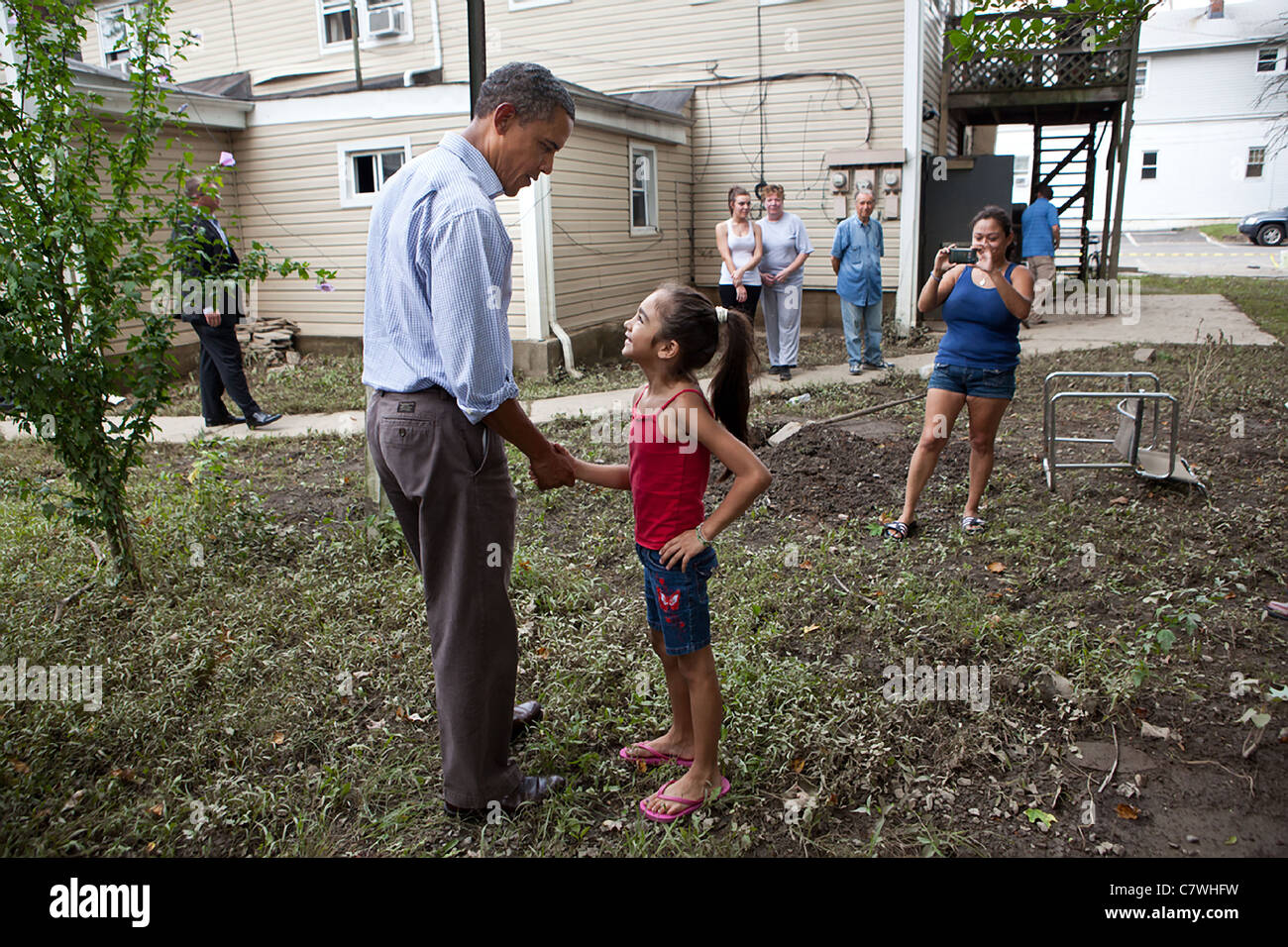 Il presidente Barack Obama saluta una bambina mentre il turismo un quartiere danneggiato dall' uragano Irene Foto Stock