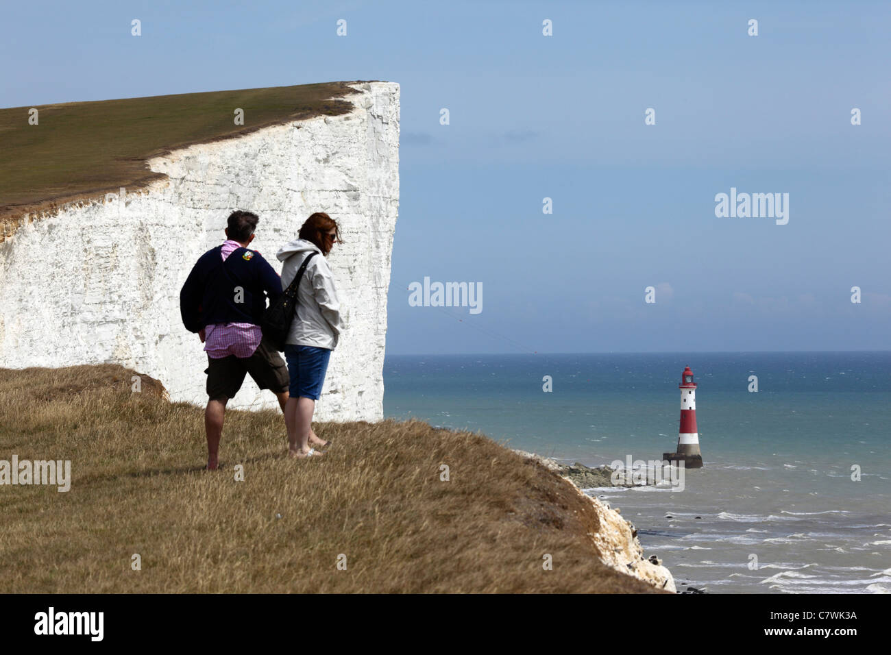 I turisti in cerca di visualizzare su South Downs costa modo percorso Beachy Head Lighthouse, vicino a Eastbourne, East Sussex , Inghilterra Foto Stock
