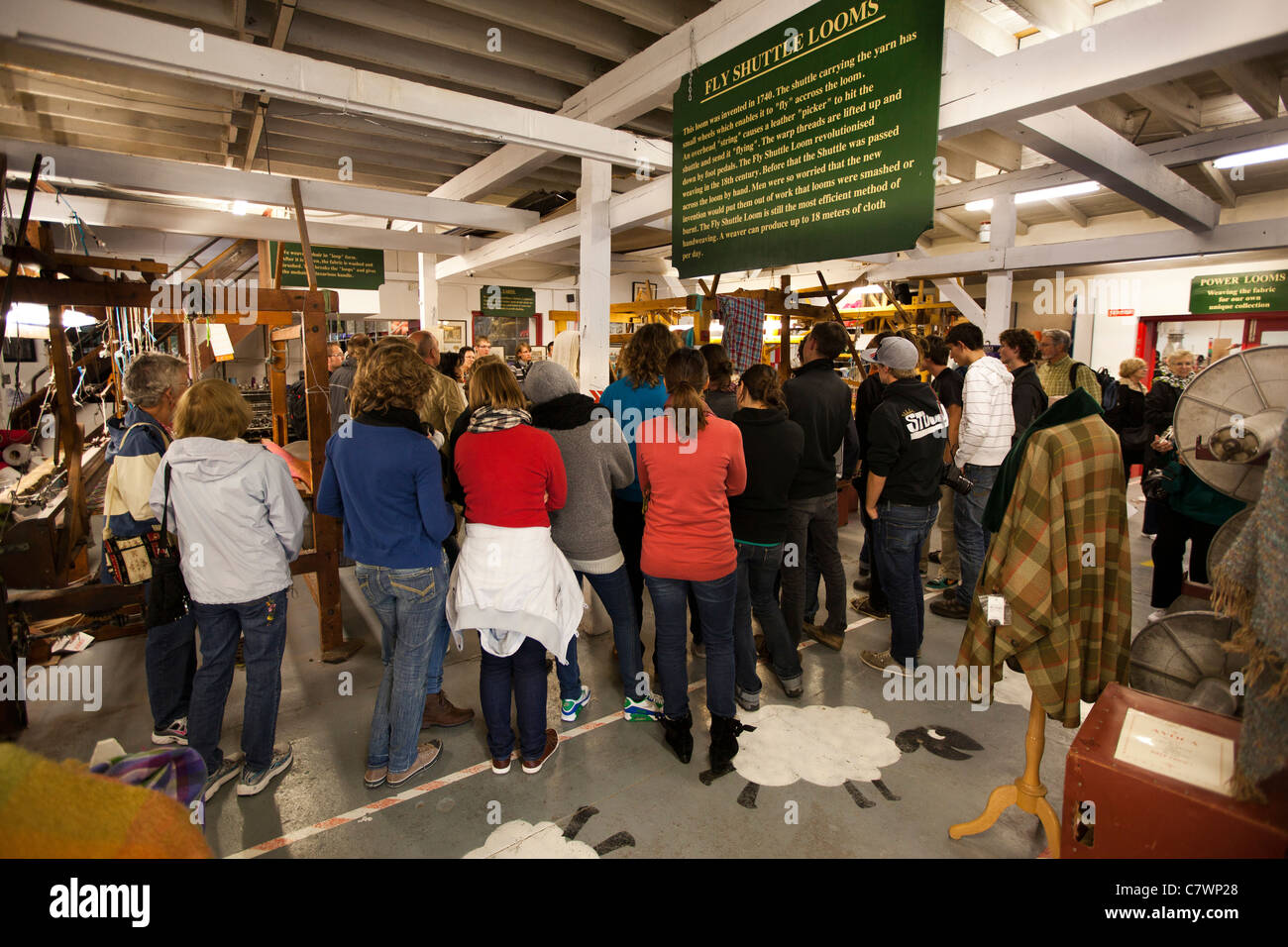 Irlanda, Co Wicklow, Avoca, gruppo di turisti tedeschi sul tour di handweaving mulino tessile guardando tessitore al telaio a mano Foto Stock